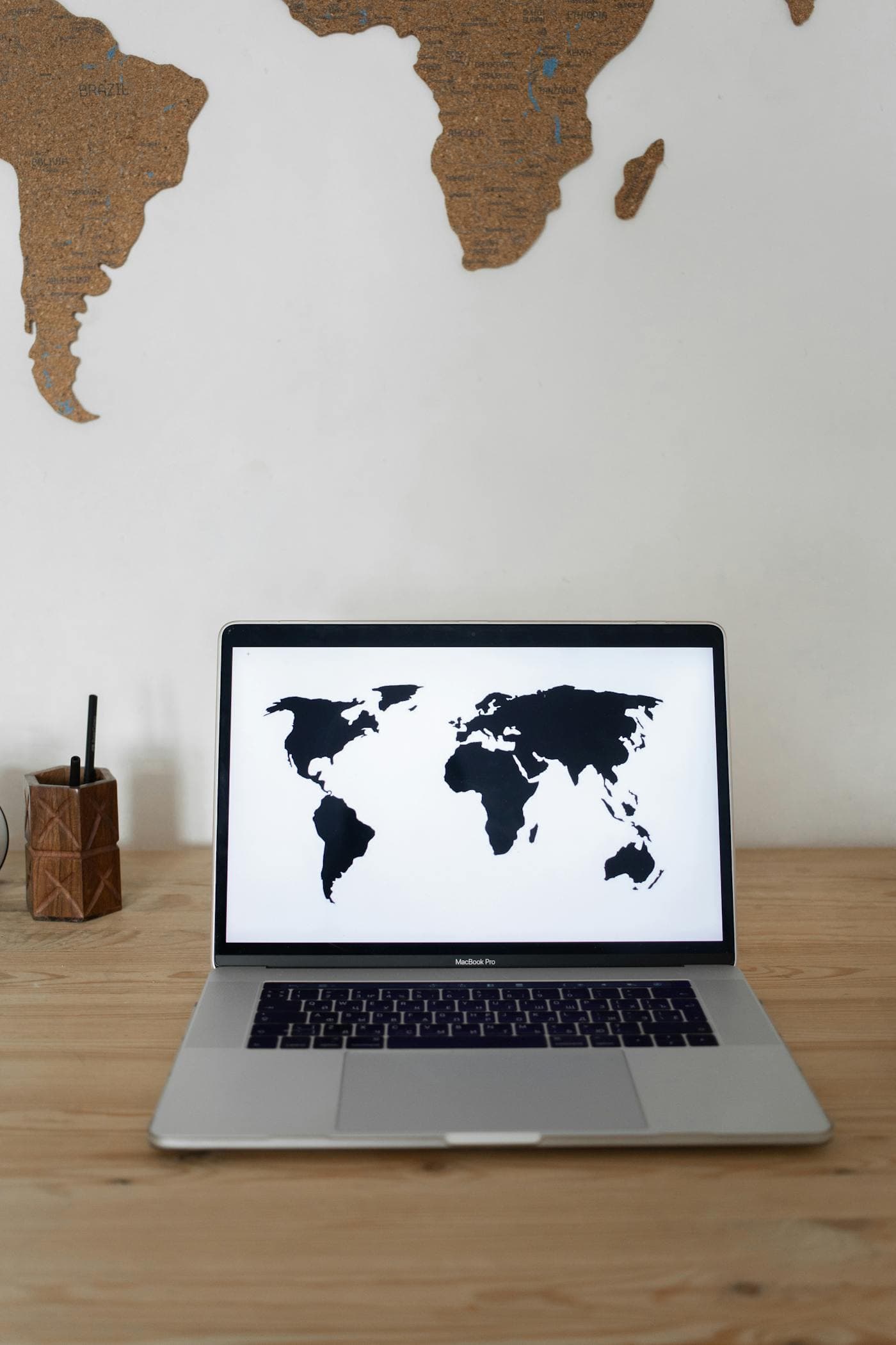 A laptop workspace with a wall map for nationwide remote consulting.